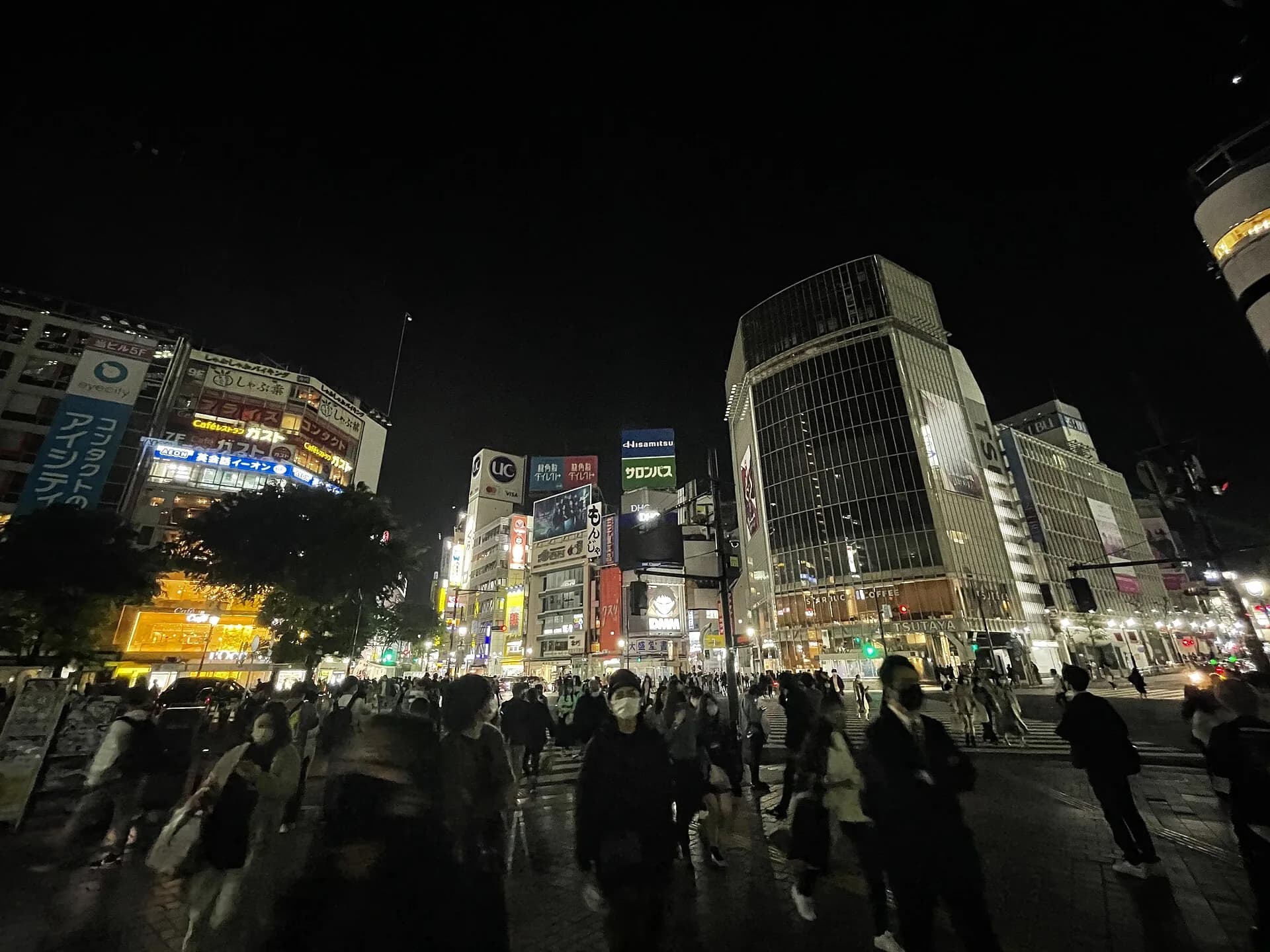De drukke Shibuya-oversteekplaats in Tokio met neonreclames, symbool van het digitale Japan
