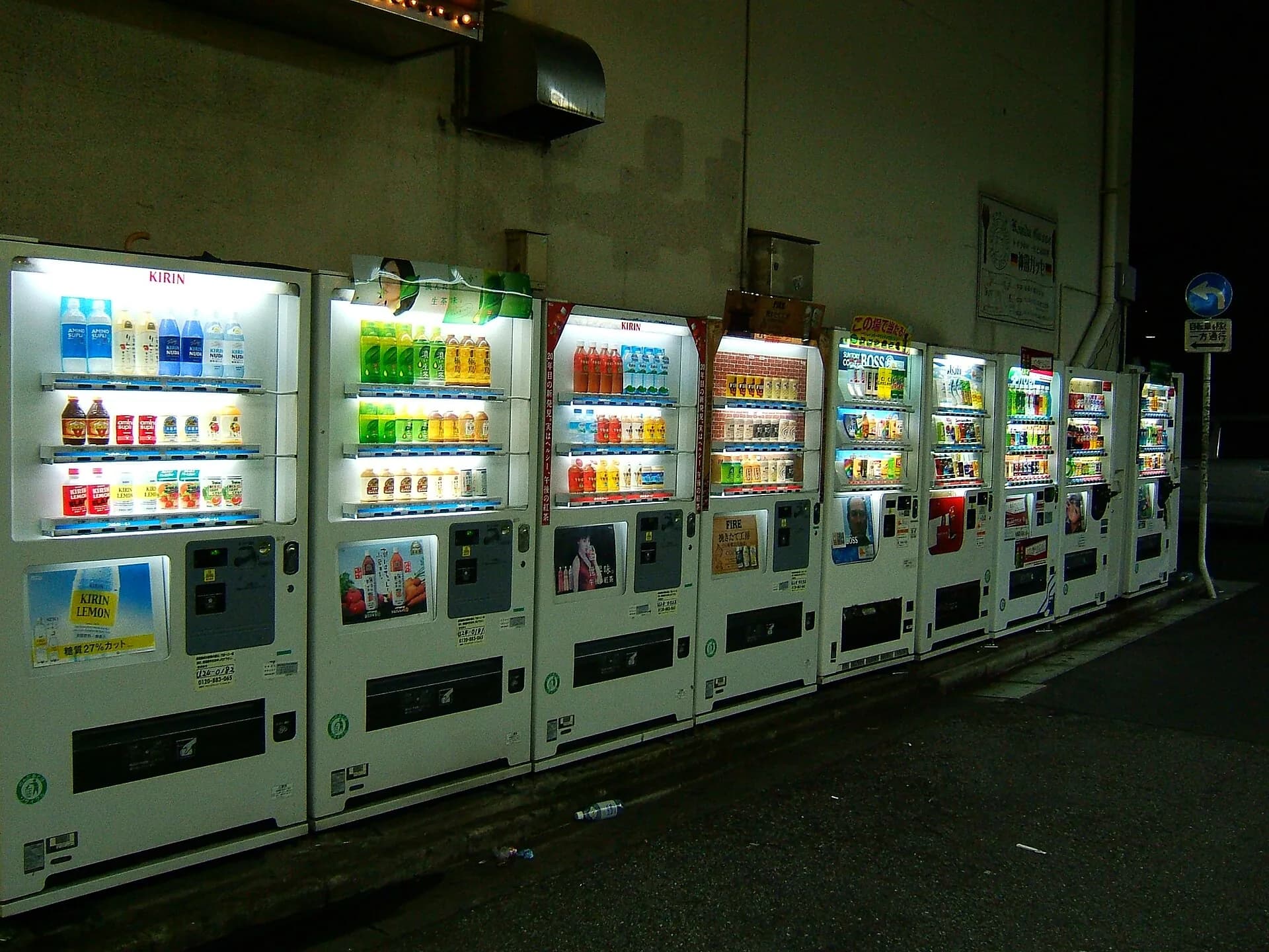 Rij verlichte verkoopautomaten in een straat in Tokio bij avond