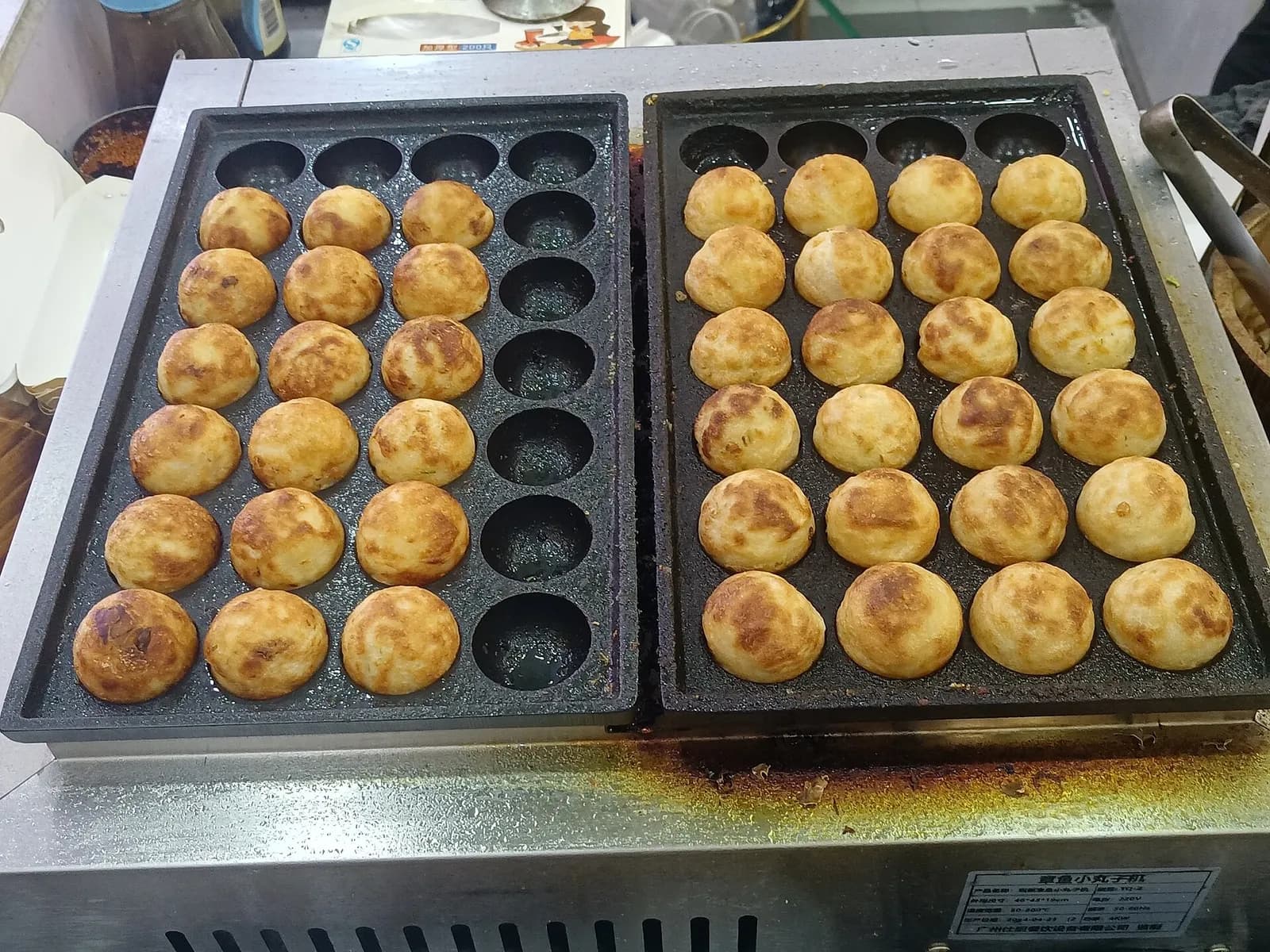 Een portie takoyaki met okonomiyaki-saus, mayonaise en katsuobushi-vlokken